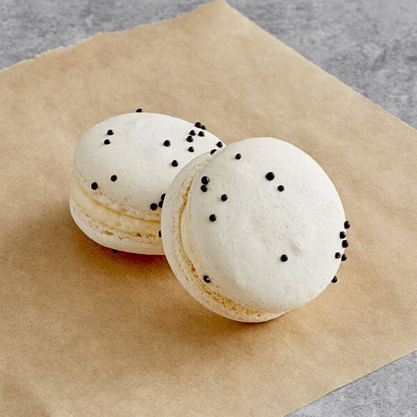 two white cookies with black dots on top