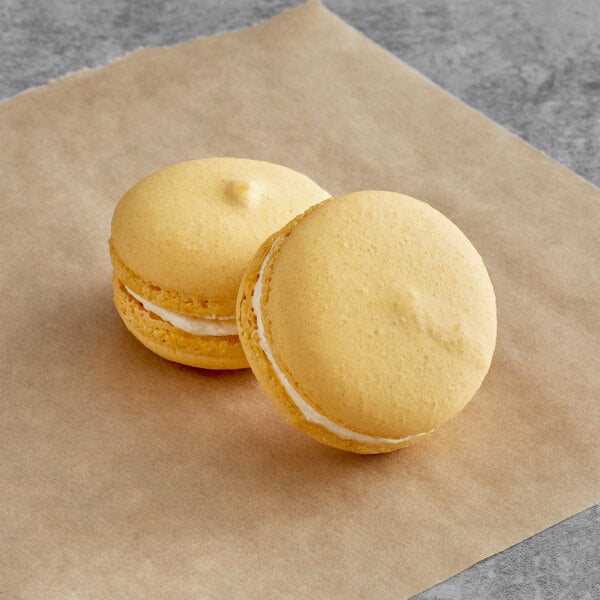 Two Macaron Centrale almond macarons on a piece of paper.