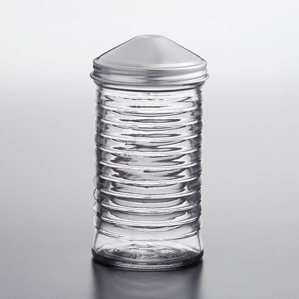 A clear glass Tablecraft sugar pourer with a stainless steel center pour top.