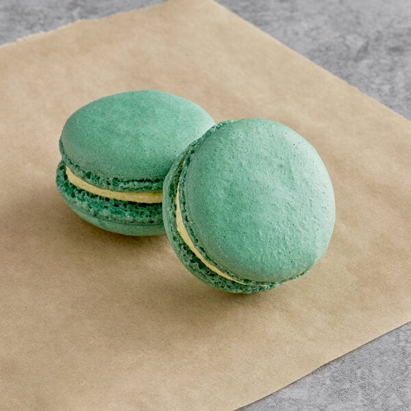 two green macaroons on a brown paper