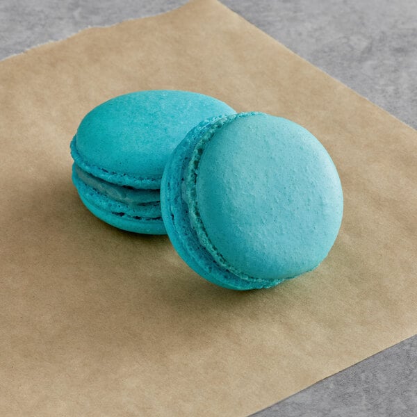 Two blue macarons on brown paper.