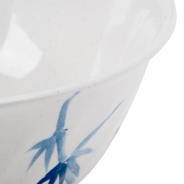 A close-up of a blue and white Thunder Group Blue Bamboo melamine bowl with a swirl design.