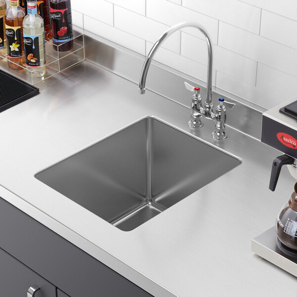A stainless steel Regency fabricated undermount sink bowl with a hole in it.