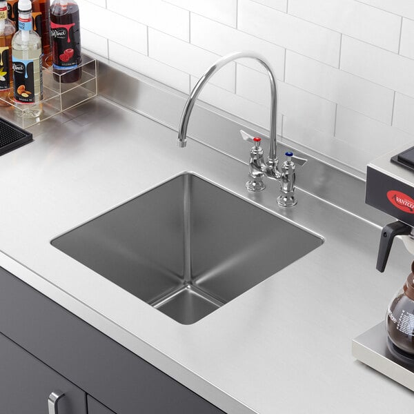 A close-up of a Regency stainless steel fabricated undermount sink bowl installed in a counter.