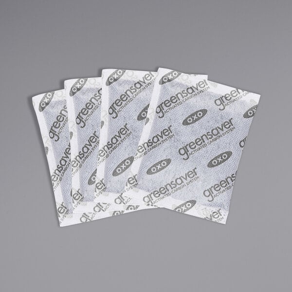 A group of white OXO GreenSaver Carbon Filter Refill packets with black text.