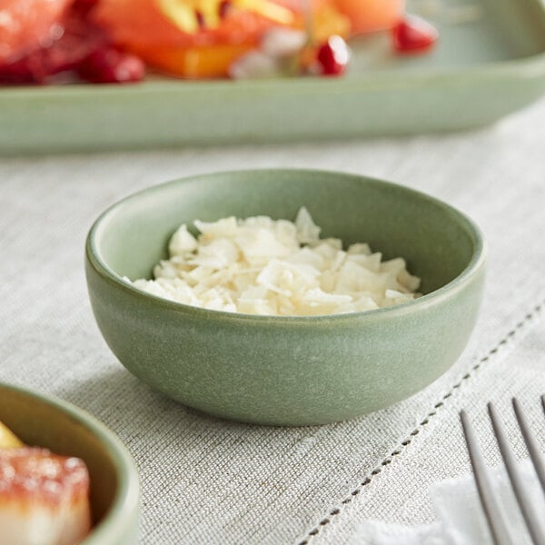 An Acopa sage ramekin filled with white food on a table.