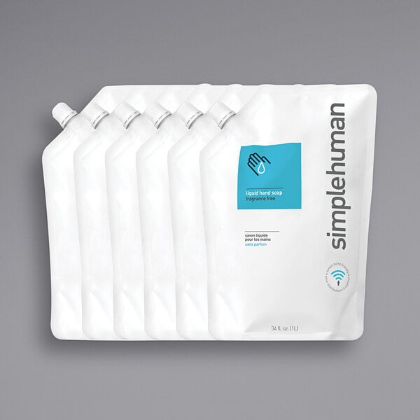 A group of simplehuman white plastic hand soap refill pouches with blue and black text.