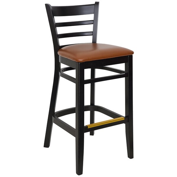 A BFM Seating black beechwood barstool with light brown vinyl seat.