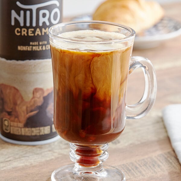 A glass cup of coffee with Reddi-Wip Nitro Creamer next to it.