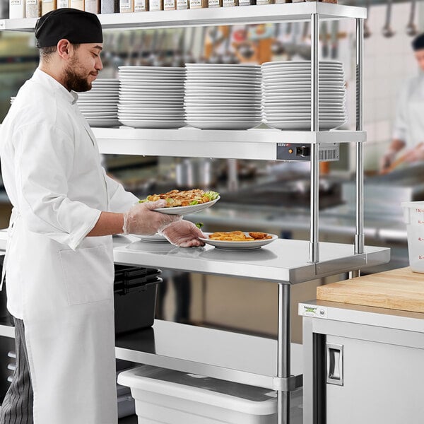 A chef using a Regency expeditor table to plate food.