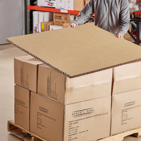 A man holding a large Lavex honeycomb cardboard panel.