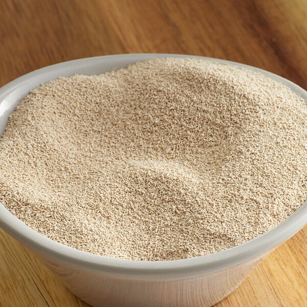 A bowl of Lesaffre red dry yeast on a wooden table.