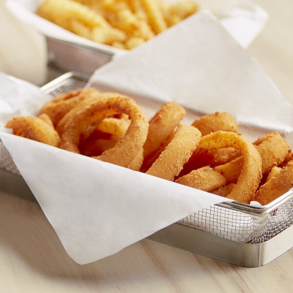 A metal basket lined with a white customizable deli wrap, holding fried onion rings.