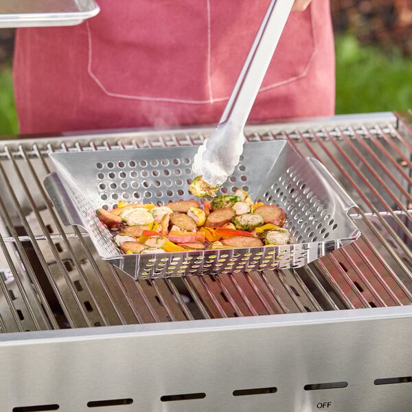 A Mr. Bar-B-Q stainless steel grill basket with food on a grill.