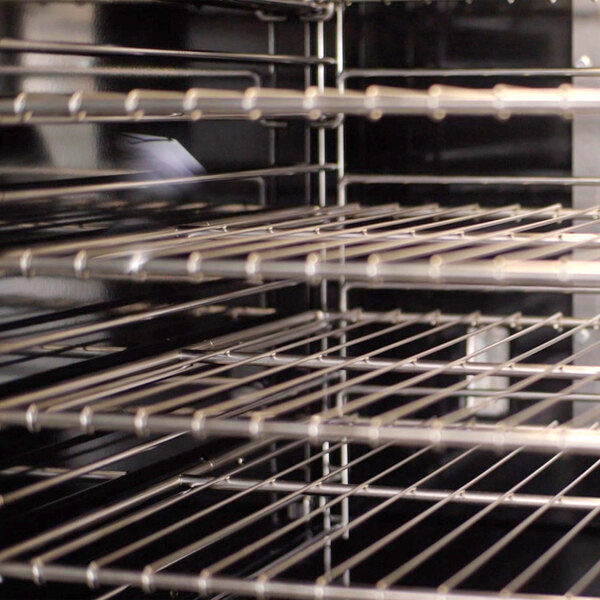 An interior view of a commercial electric convection oven with multiple metal racks.