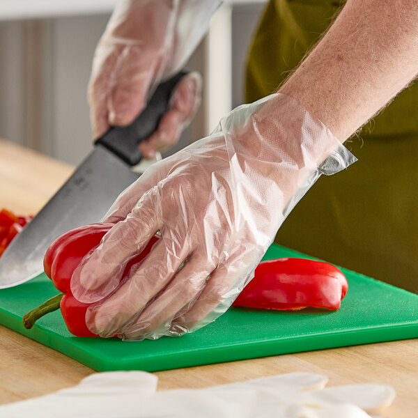 A hand in an AeroGlove cutting a red pepper.