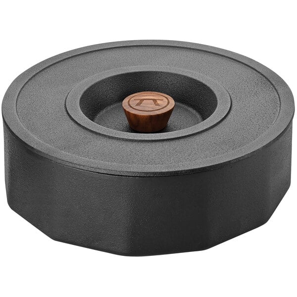 A black round object with a wooden handle.