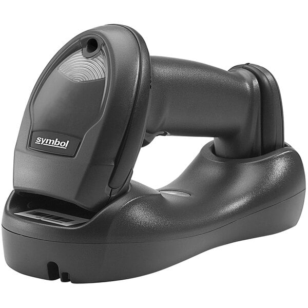 A Zebra black barcode scanner with a cord in a standard cradle.