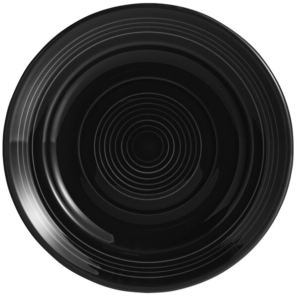 A black Tuxton Concentrix china plate with a spiral pattern.