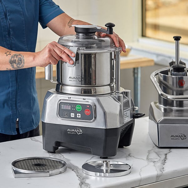 A man using an AvaMix Goliath combination food processor on a counter.