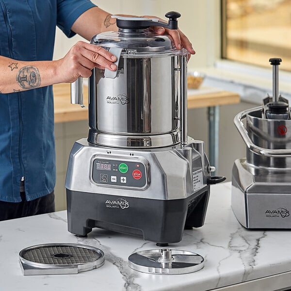 A person using the AvaMix Goliath combination food processor on a counter.