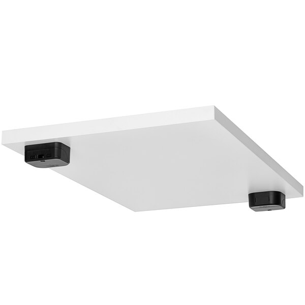 A white rectangular tabletop with black wireless chargers on it.