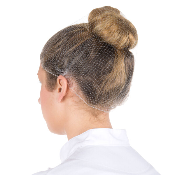 A woman wearing a Royal Paper white hairnet over a bun.