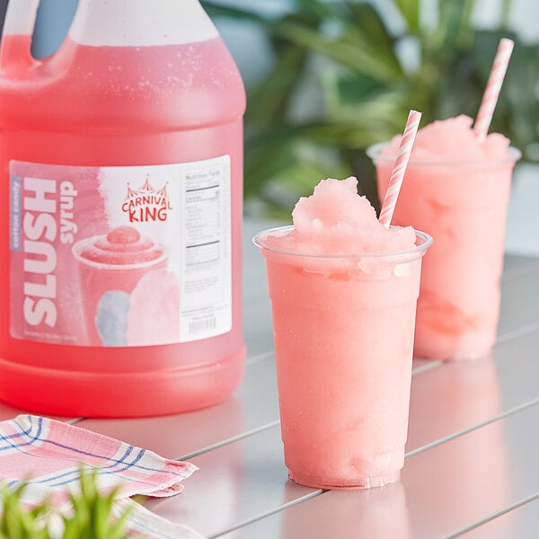 A pink slushy drink in a plastic cup with a straw.