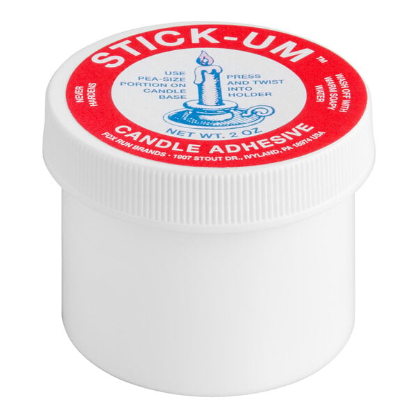 A white plastic container with a red and white lid labeled 'Stick-Um Candle Adhesive' and instructions for use.
