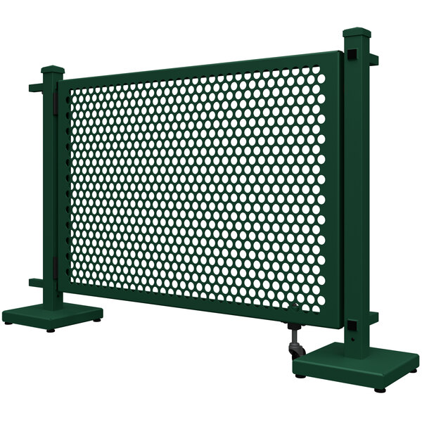 a green metal fence with holes