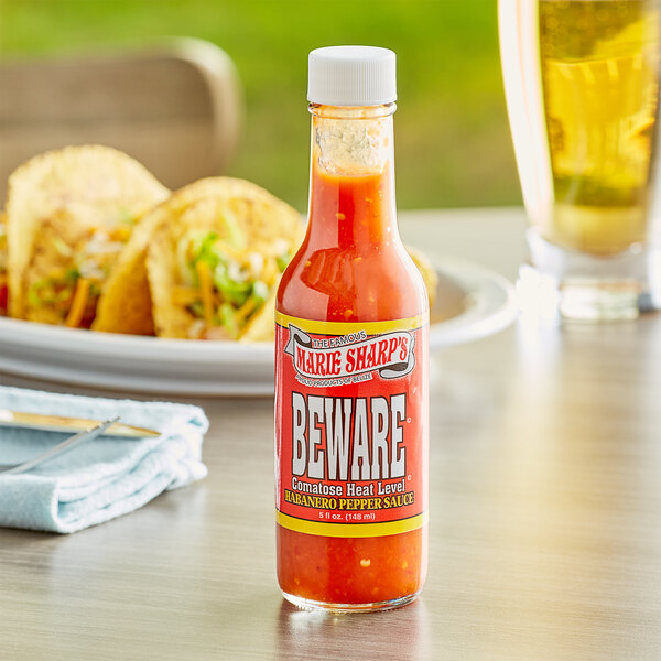 A case of Marie Sharp's Beware Comatose Habanero Hot Sauce on a table with tacos.