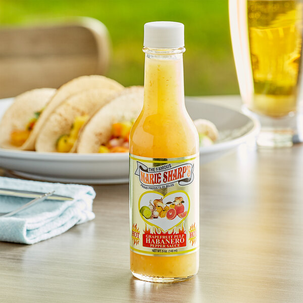 A bottle of Marie Sharp's grapefruit habanero hot sauce on a table in a Mexican restaurant.