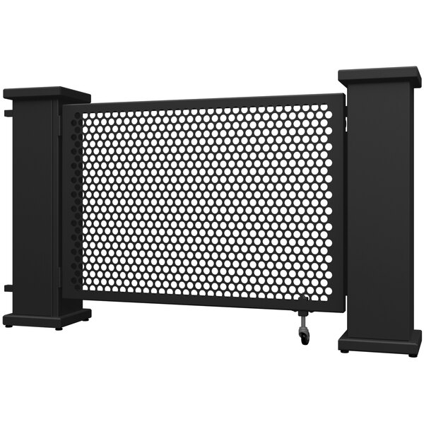 A black metal gate with a circle pattern and planter stands on each side.
