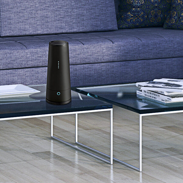 A black Guardian Technologies Germ Guardian air sanitizer on a glass coffee table.