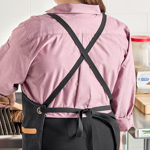 A woman wearing a Backyard Pro grilling apron cooking on a grill.