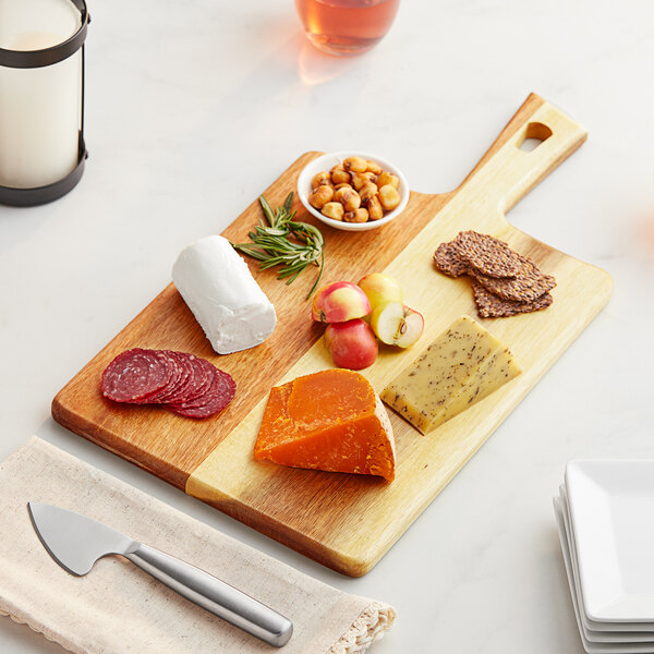 An Acopa acacia wood serving board with cheese, nuts, and a knife.