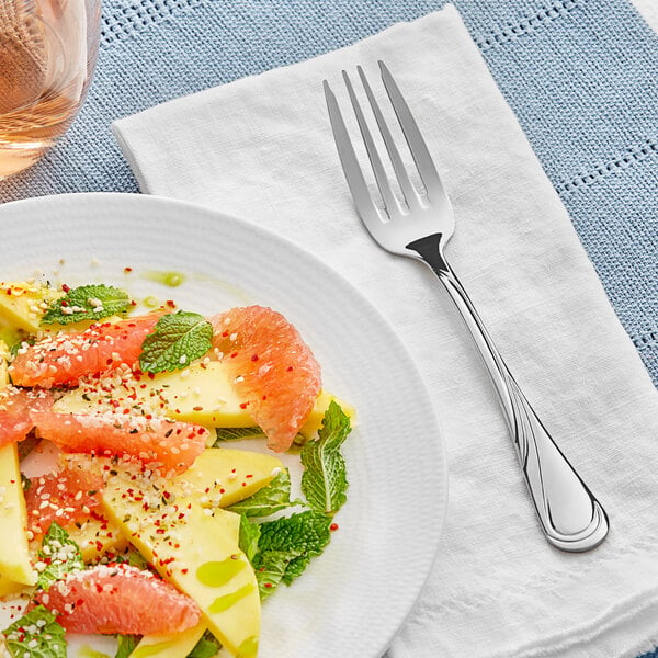 A plate of fruit salad with an Acopa stainless steel salad fork.