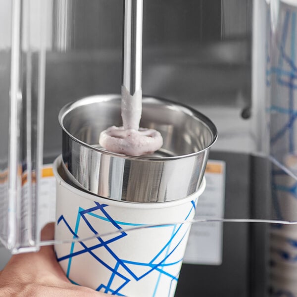 A hand holding a stainless steel malt cup over ice cream.