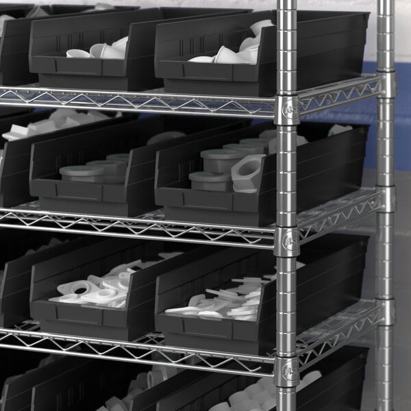 A metal shelving unit with black Regency Shelf Bins containing white cups.