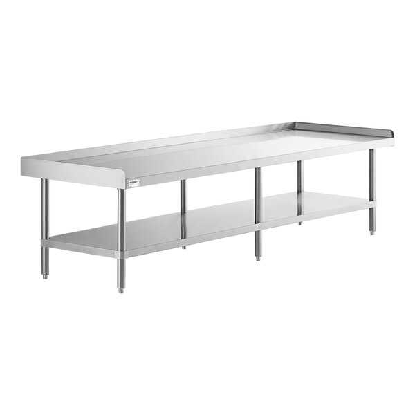 A long stainless steel table with an undershelf and raised edges on three sides.