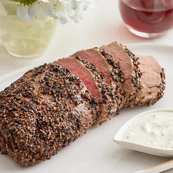 A plate of meat seasoned with Regal Cracked Black Pepper.