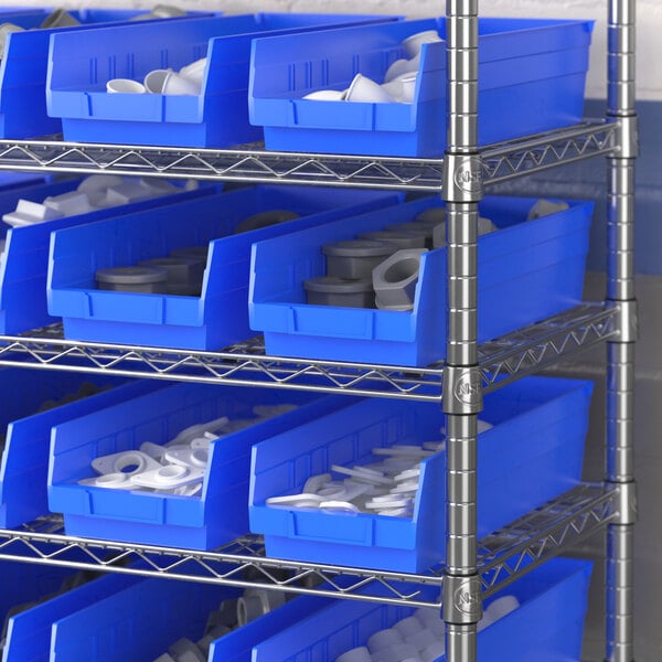 A blue Regency shelf bin on a metal shelf with grey objects inside.