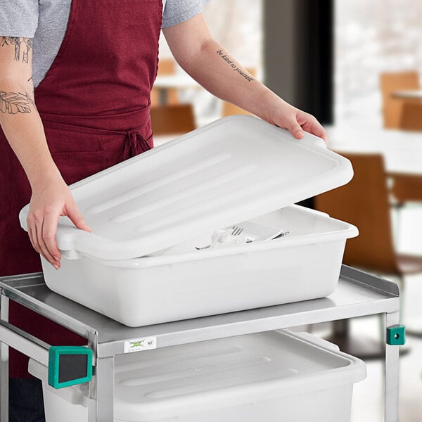 A woman in an apron opening a white Choice polypropylene container on a counter.