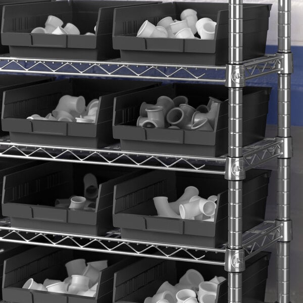 A metal shelf with black Regency plastic bins on it.