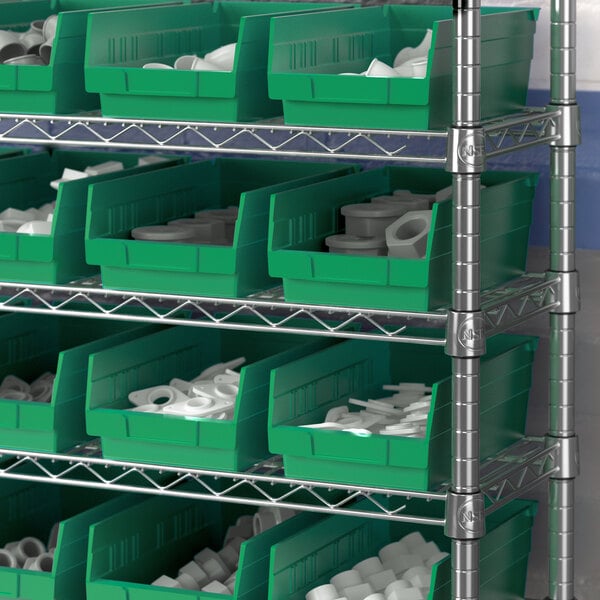 A shelf with Regency green plastic bins holding white objects.