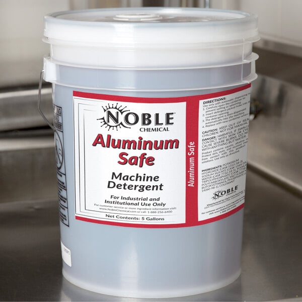 A 5 gallon bucket of Noble Chemical Metal Safe dishwashing liquid on a counter.