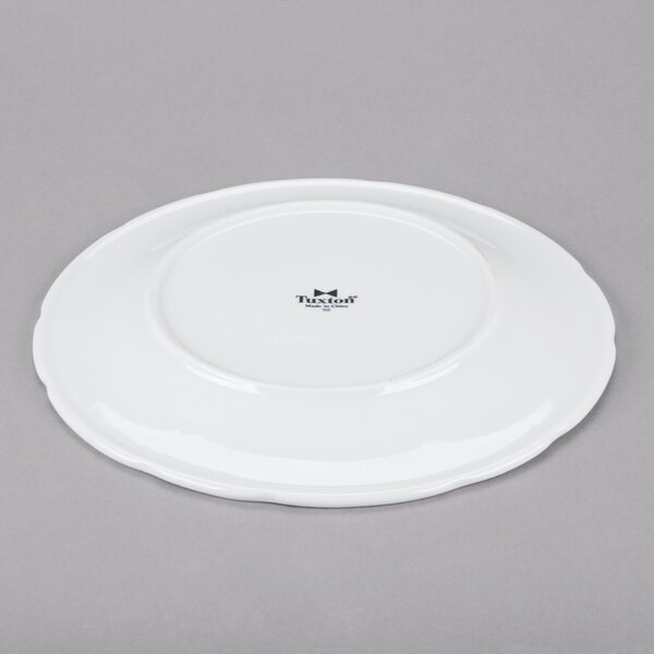 A Tuxton bright white china plate with a small black rim.