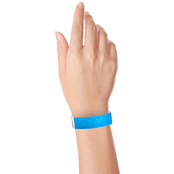 A close-up of a hand with a blue Carnival King wristband.