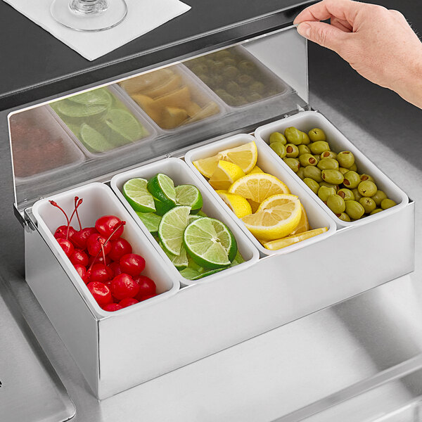 A Tablecraft stainless steel condiment bar with fruit and vegetables in the containers.