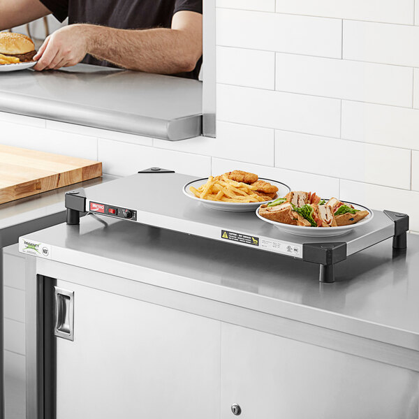 A man using a Metro countertop shelf warmer to prepare food on a white surface.